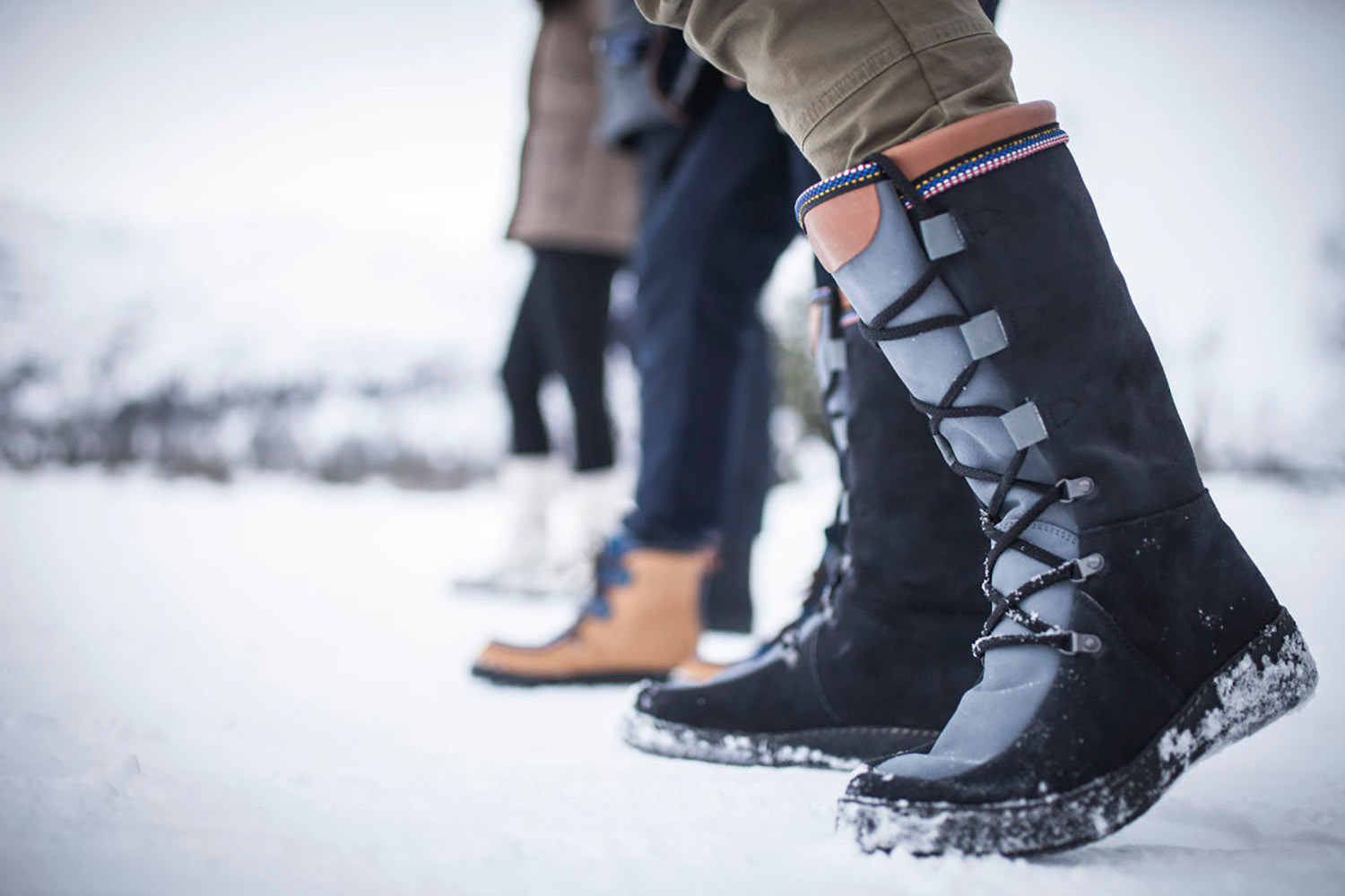 people in the snow wearing topaz of norway boots