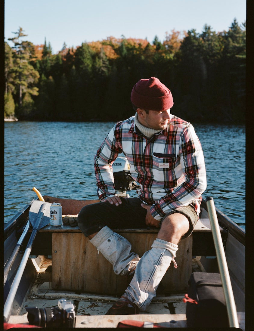 man in a boat wearing amundsen skauen field shirt in checkered red