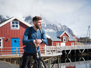 man riding a bike in organic wool and silk shirt by northern playground for aktiv outdoor wear