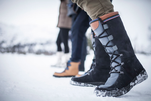 people in the snow wearing topaz of norway snow boots