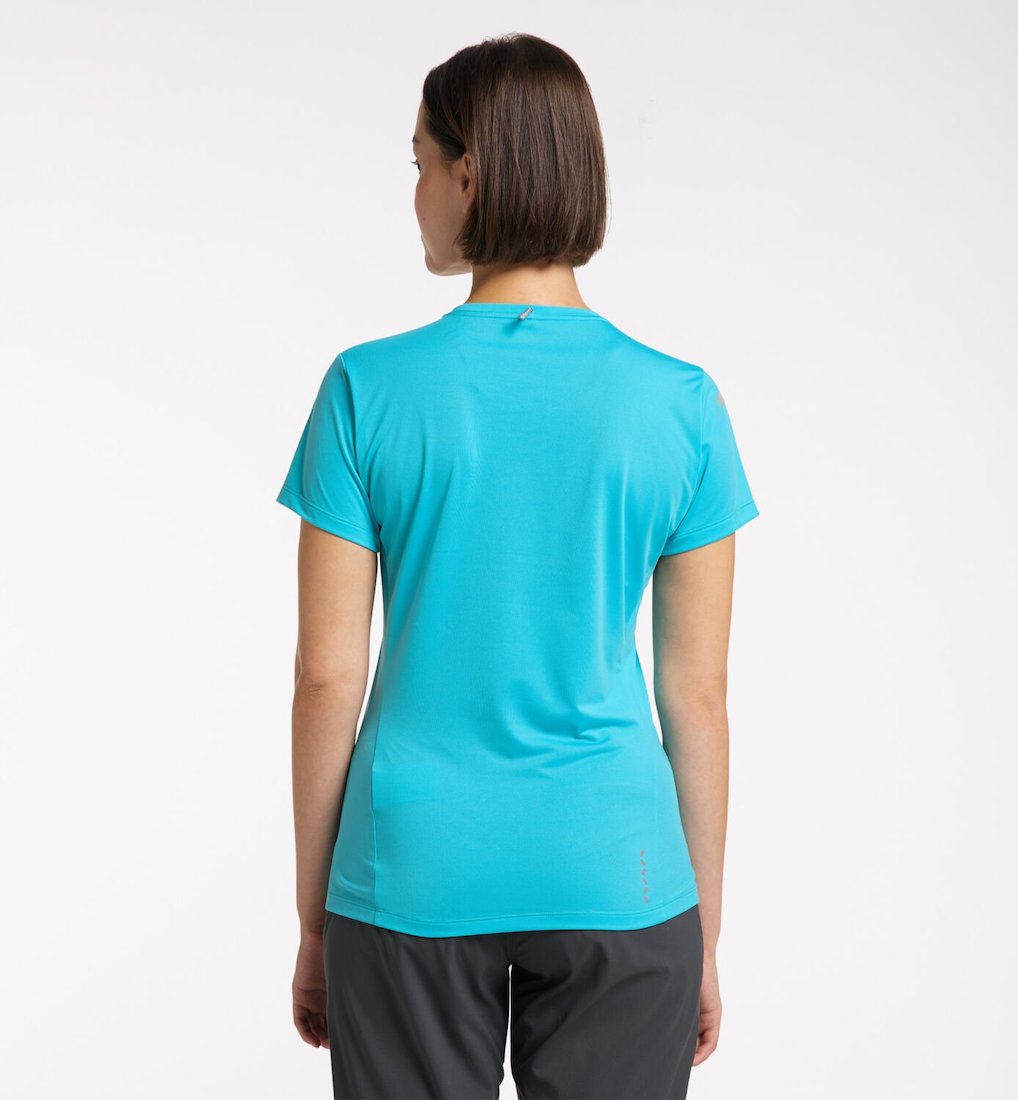 Back view of model wearing blue L.I.M. Tech Tee.