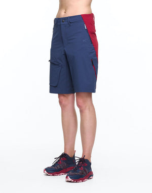 Front view of model wearing color block hiking shorts in red and blue.
