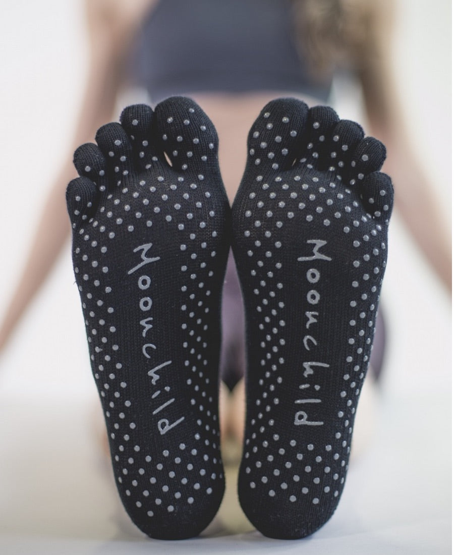 Bottom of black toe socks with moonchild written on them