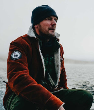Stoic man in a boat wearing corduroy jacket with Wool inner liner by Amundsen Sports