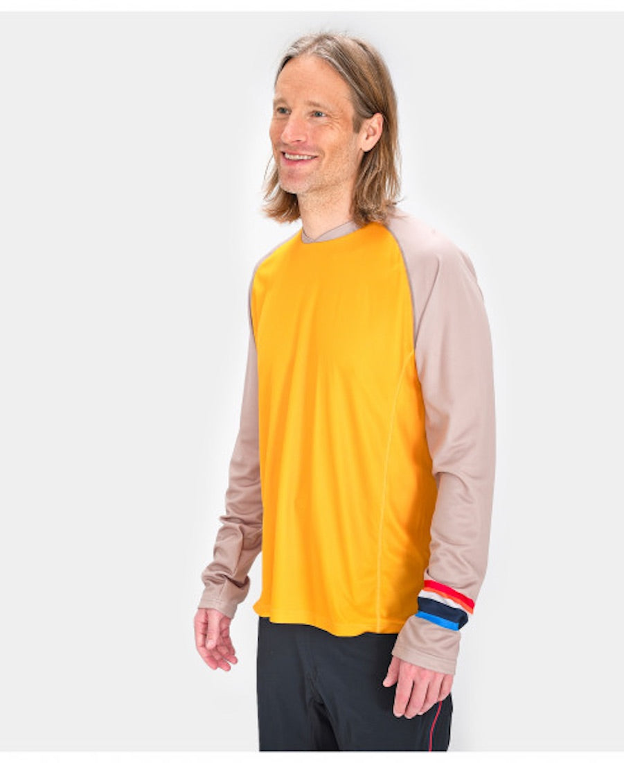 Front view of model wearing Allmountain long sleeve shirt in yellow with gray sleeves.