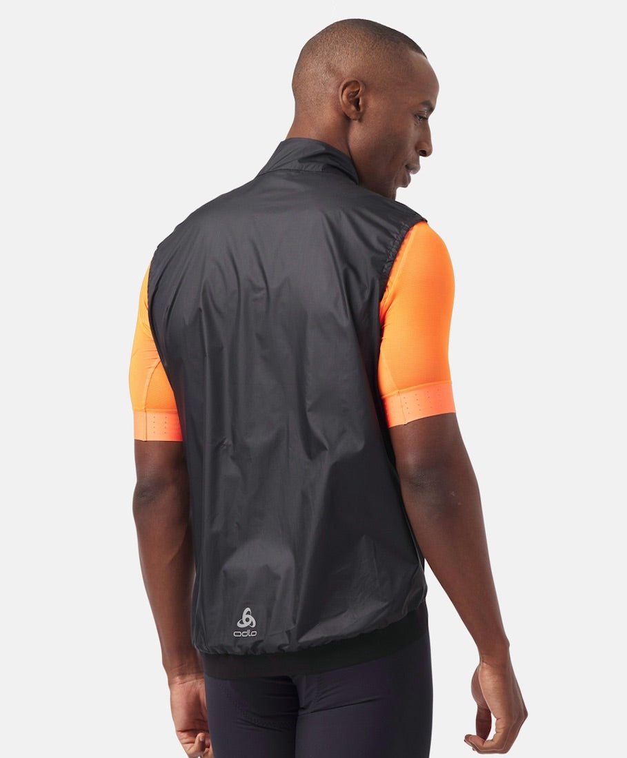 Back view of model wearing essential windproof vest in black.