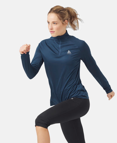 Front view of model in running position wearing Essential half zip in navy blue.