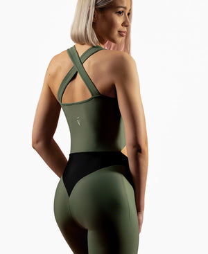 3/4 view of woman wearing olive green VanillaShanti one-piece yoga bodysuit or unitard
