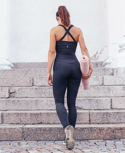 Back view of woman wearing black VanillaShanti one-piece yoga bodysuit or unitard