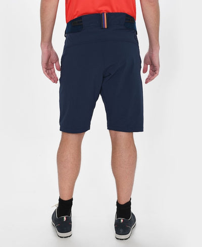 Back view of model wearing Versatility shorts in dark blue.